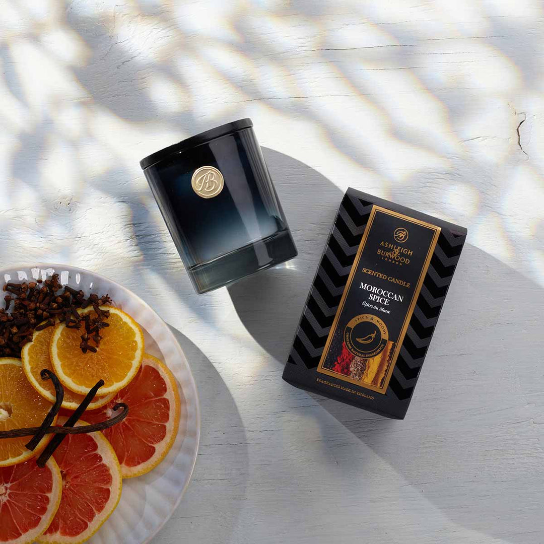 Moroccan Spice Scented Candle next to a plate of orange slices