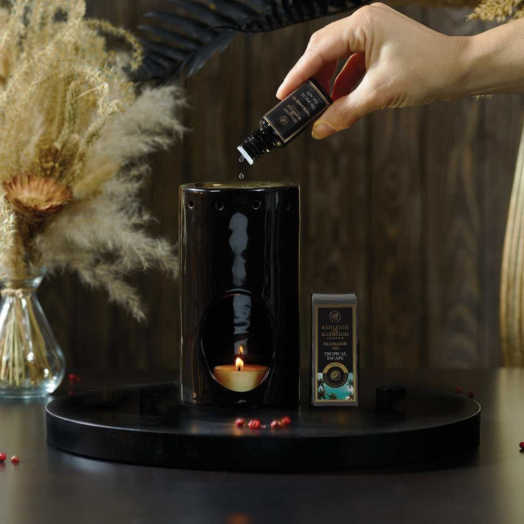 Tropical Escape Fragrance Oil being poured into an Oil Burner