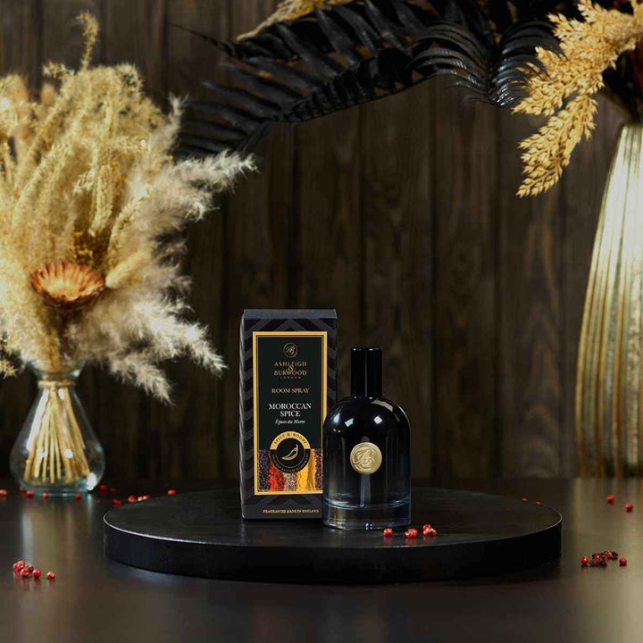 Moroccan Spice Signature Room Spray pictured next to its box against a dark background