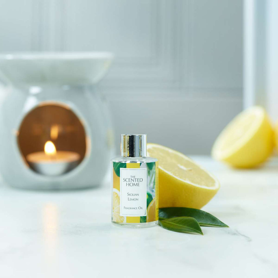 A bottle of Sicilian Lemon Fragrance Oil with a burning Oil Burner in the background