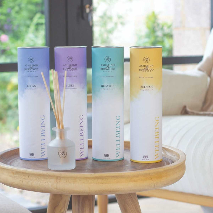 Wellbeing Diffusers on a table with sofa in the background