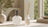 A picture of a Fragrance Lamp and Reed Diffuser side by side in the home on a table