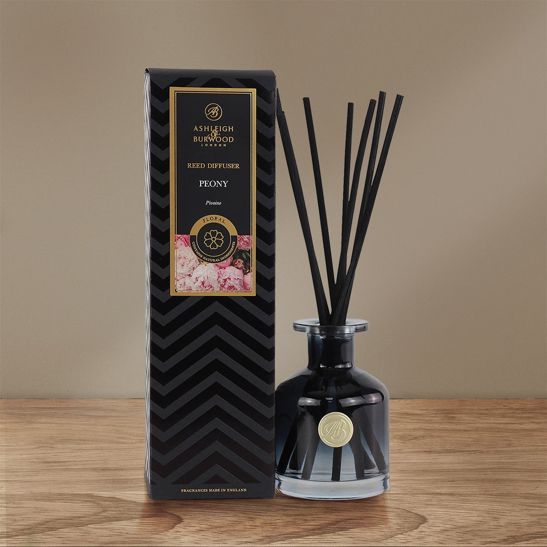 Peony Signature Reed Diffuser sitting on a wooden surface