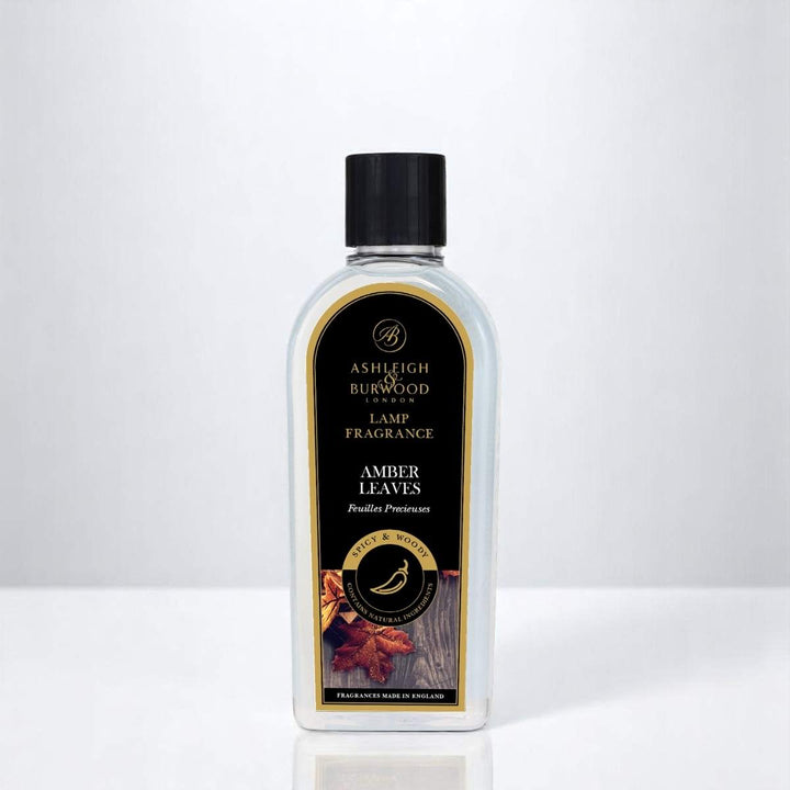 A bottle of Amber Leaves Lamp Fragrance against a white neutral background
