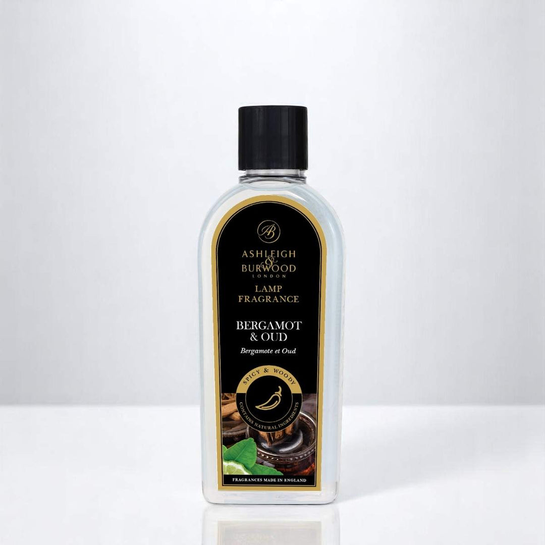 A bottle of Bergamot & Oud Lamp Fragrance against a white neutral background