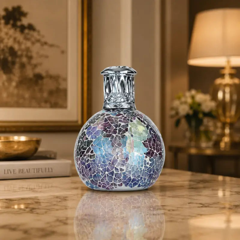 Decorative glass vase with mosaic pattern on a marble surface