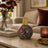 Decorative bottle with mosaic design on a marble surface in a living room setting.