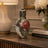 Decorative mosaic vase on a table with a lamp and books in the background