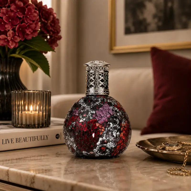Decorative bottle with floral design on a table with books and flowers in the background