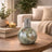 Decorative mosaic lamp on a wooden table with a cozy living room background