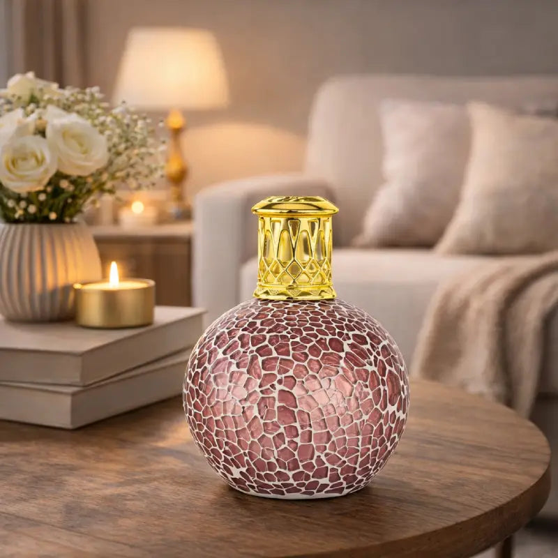 Decorative candle with a gold top on a wooden table in a cozy living room.