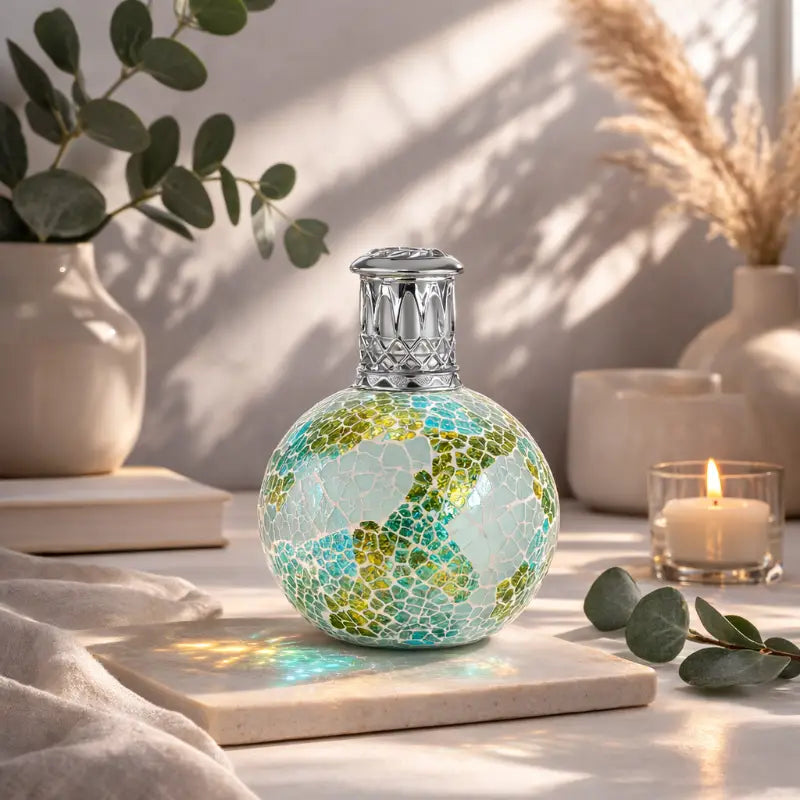 Decorative lamp with mosaic design on a table with plants and candles
