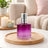 Purple perfume bottle on a wooden tray with a cozy living room background