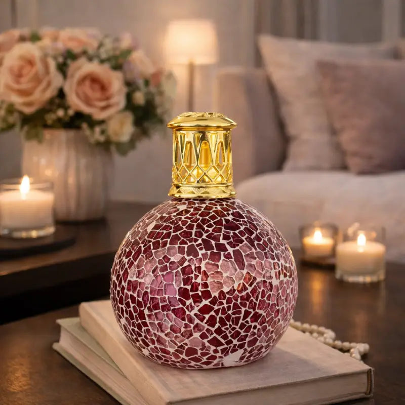 Decorative lamp with mosaic design on a table in a cozy living room setting.