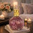 Decorative lamp with mosaic design on a table in a cozy living room setting.