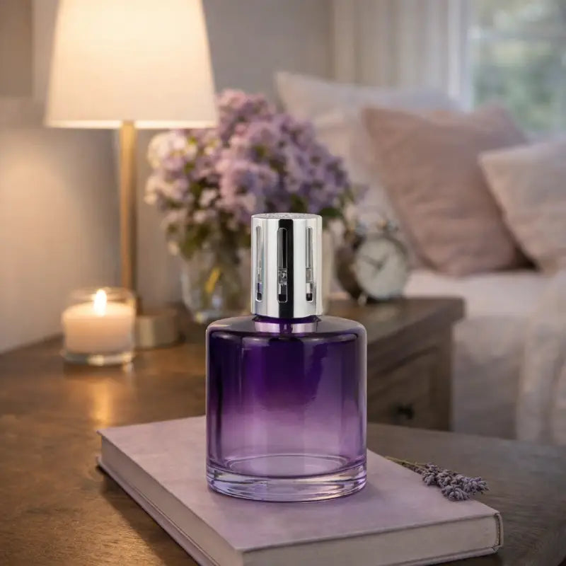 Purple perfume bottle on a book with a cozy living room background