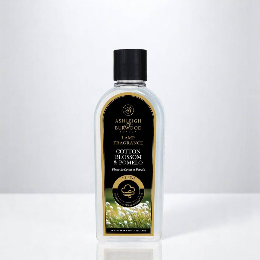 A bottle of Cotton Blossom & Pomelo Lamp Fragrance against a white neutral background