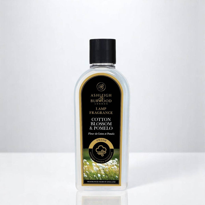 A bottle of Cotton Blossom & Pomelo Lamp Fragrance against a white neutral background