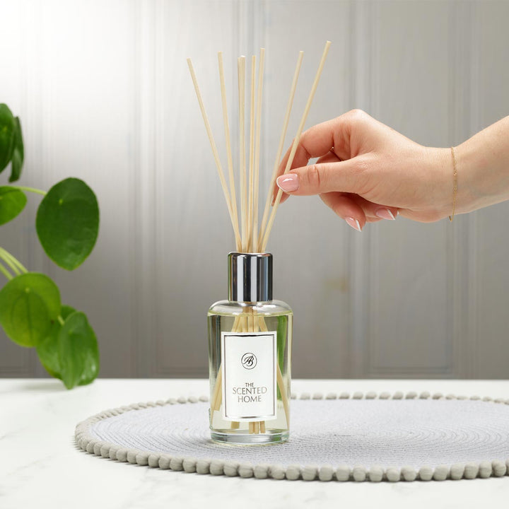 Hand placing reeds in Honeysuckle Blooms Reed Diffuser