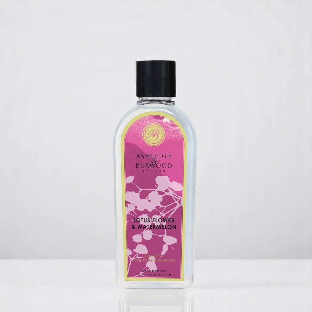 A bottle of Lotus Flower & Watermelon Lamp Fragrance against a white neutral background