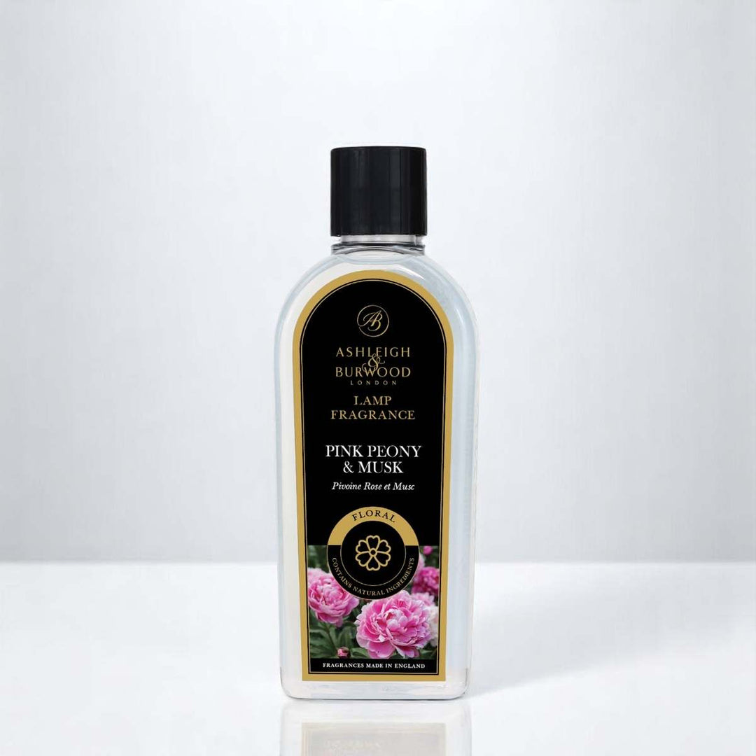A bottle of Pink Peony & Musk Lamp Fragrance against a neutral background