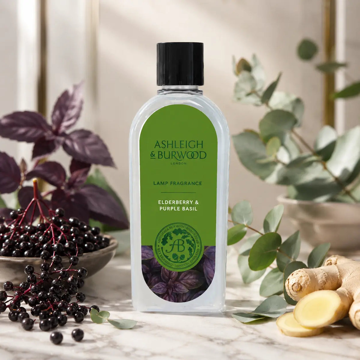 A bottle of Ashleigh & Burwood London Elderberry & Purple Basil lamp fragrance, styled on a marble surface with fresh eucalyptus, purple elderberries, ginger, and a bowl of dark berries.