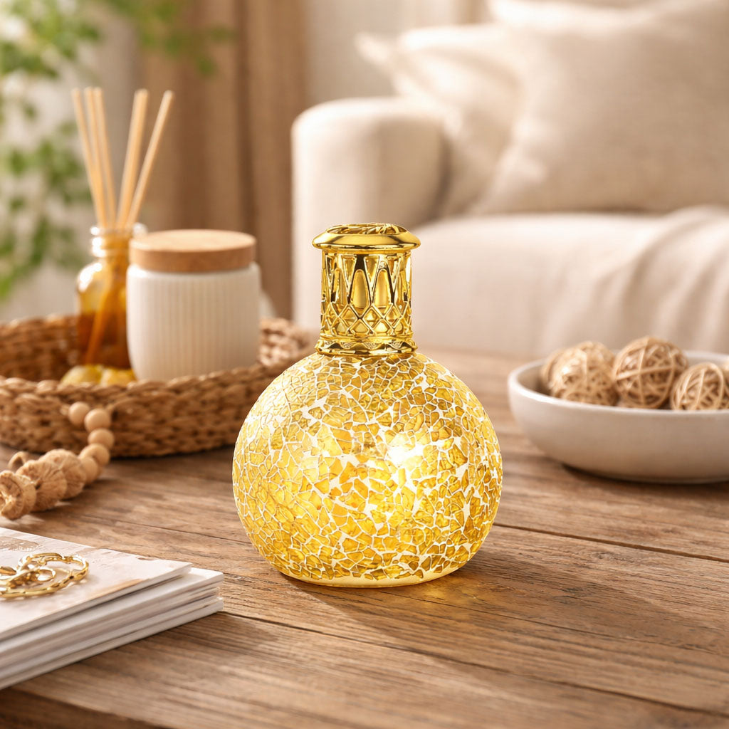 Decorative lamp with mosaic design on a wooden table in a cozy living room setting.