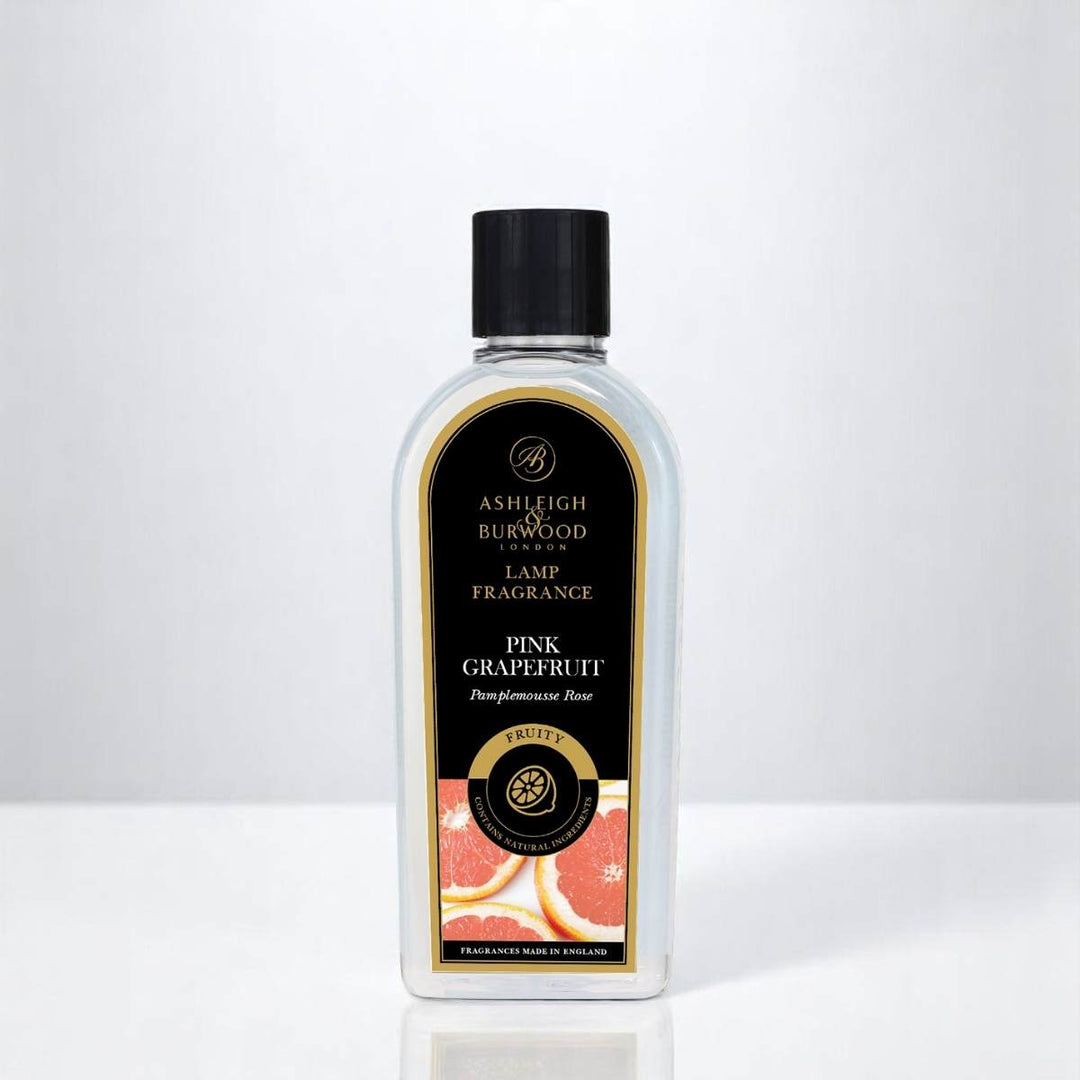 A bottle of Pink Grapefruit Lamp Fragrance against a white neutral background