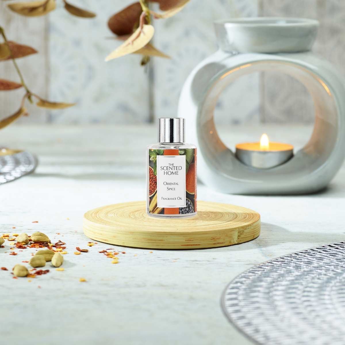 Oriental Spice Fragrance Oil in the foreground with a burning Oil Burner in the background