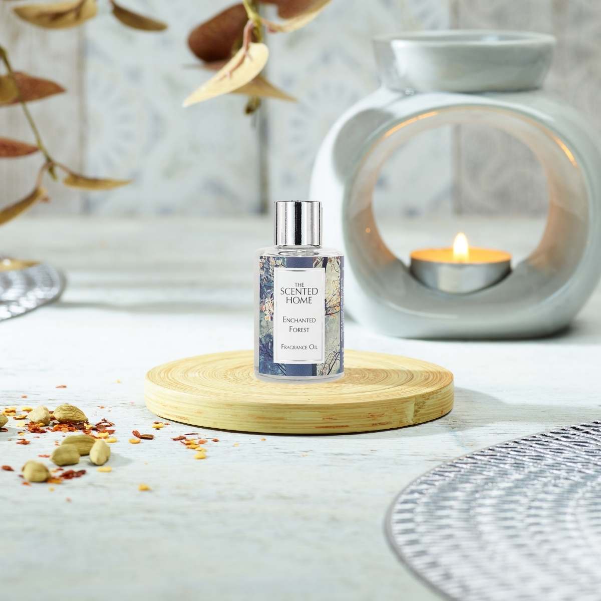 Enchanted Forest Fragrance Oil in the foreground with a lit Oil Burner in the background
