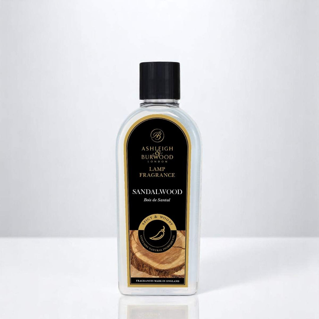 A bottle of Sandalwood Lamp Fragrance against a white neutral background