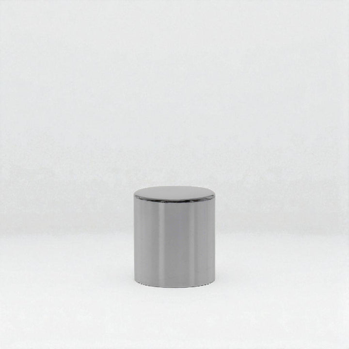Small silver snuffer cap against a white neutral background