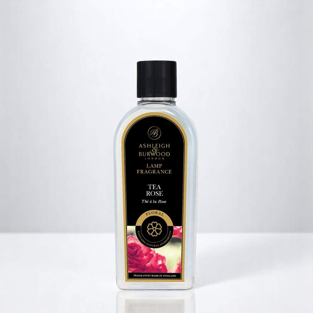 A bottle of Tea Rose Lamp Fragrance against a white neutral background