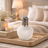 Decorative lamp on a wooden tray with a candle and flowers in a bedroom setting