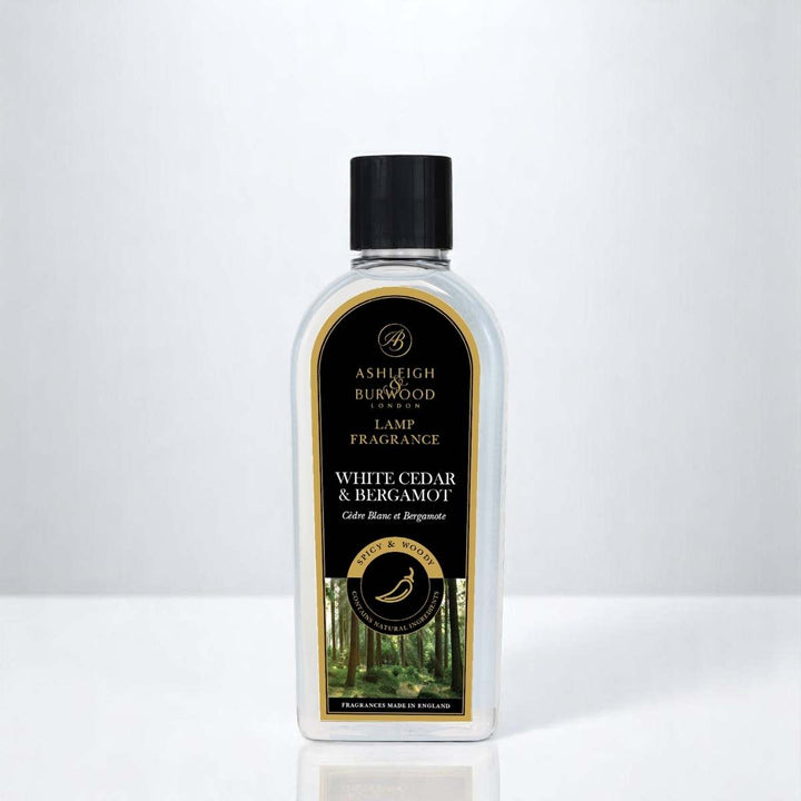 A bottle of White Cedar & Bergamot Lamp Fragrance against a white neutral background