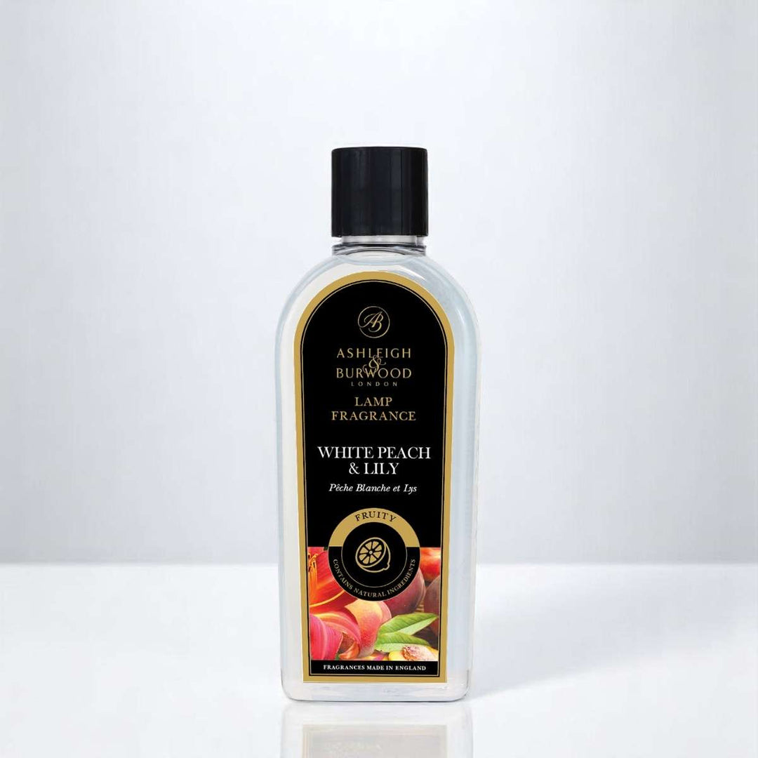 A bottle of White Peach & Lily Lamp Fragrance against a white neutral background