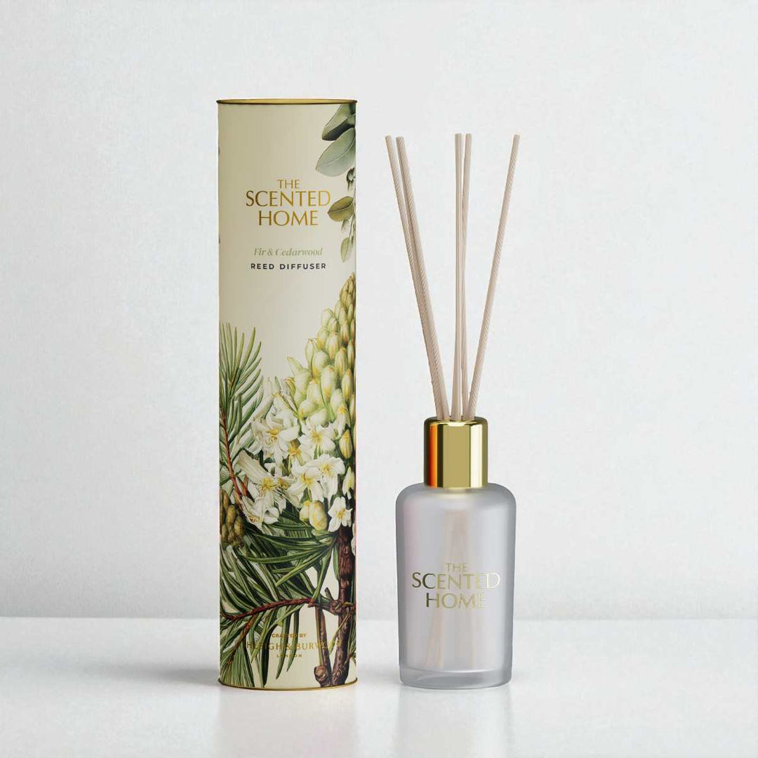 Reed diffuser with decorative packaging featuring botanical design on a white background