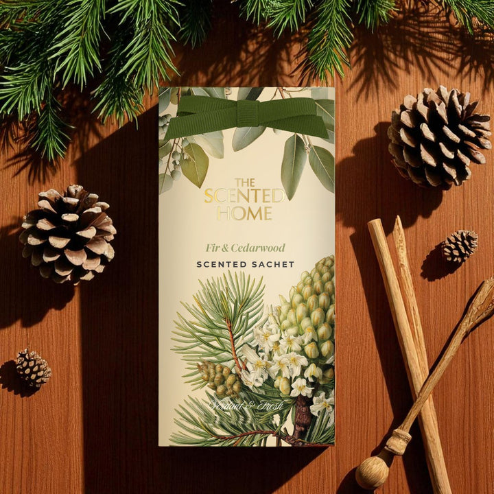 Scented sachet with botanical design on a wooden surface with pine cones and sticks.