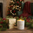 Candle and packaging with Christmas decorations on a wooden surface
