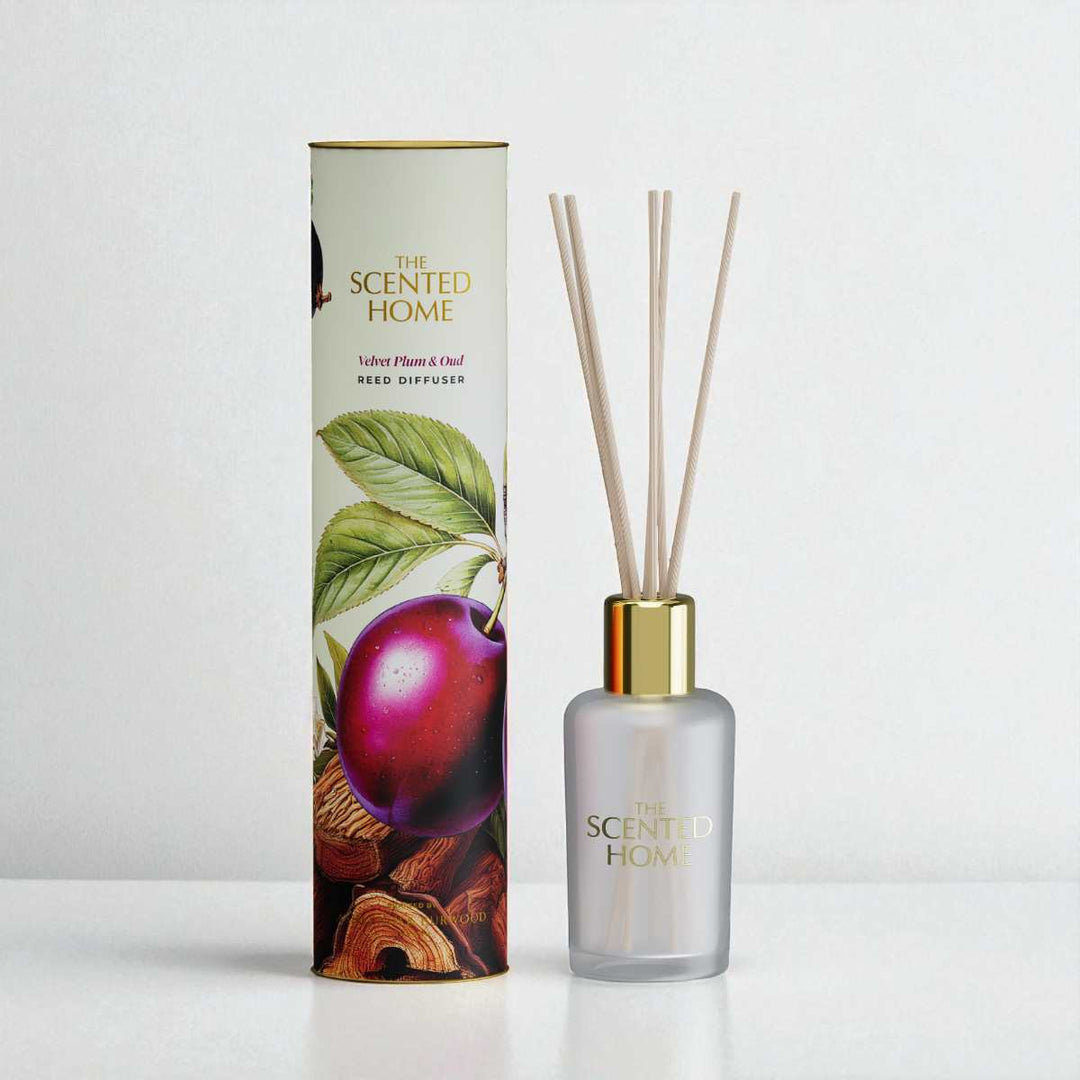 Reed diffuser with packaging featuring fruit and leaf design on a white background