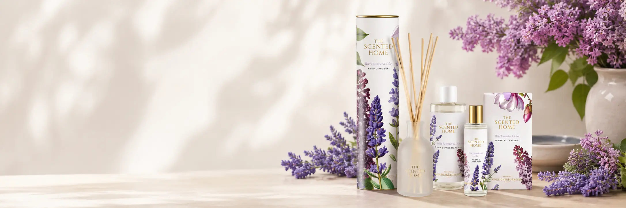 Lavender-themed products including a diffuser, candles, and flowers on a neutral background