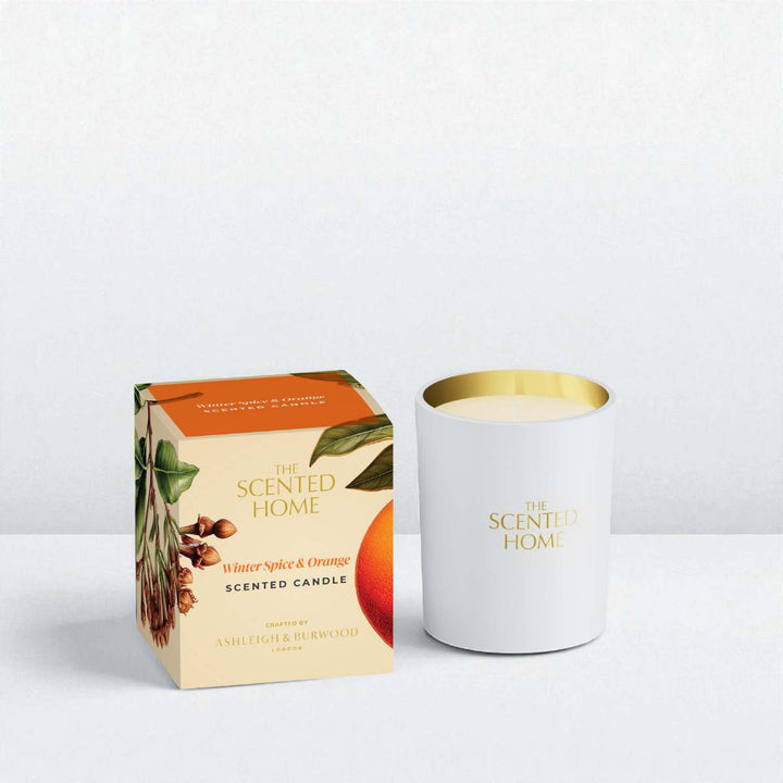 Scented candle with packaging labeled 'The Scented Home' on a light gray background